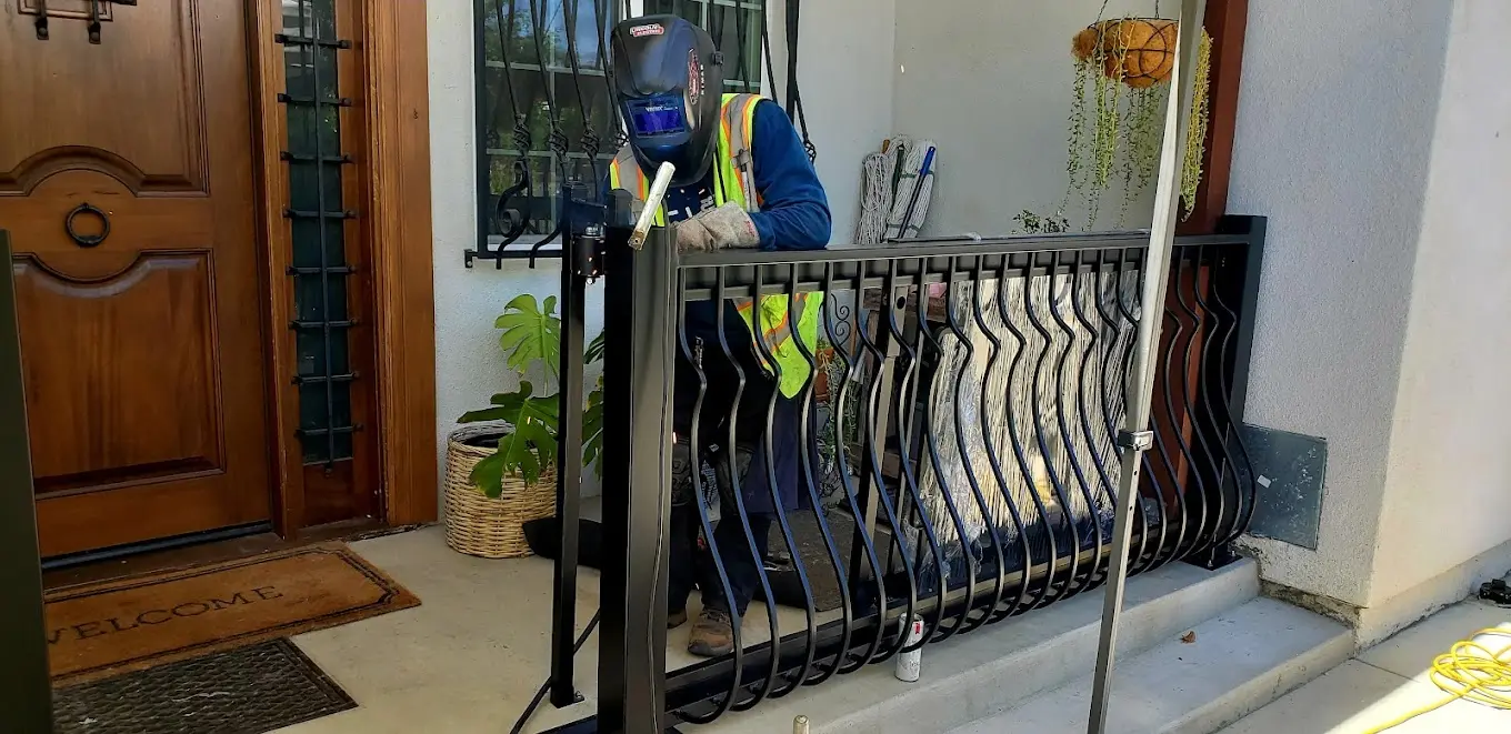 DC Iron welder welding a curved porch railing at a home entrance