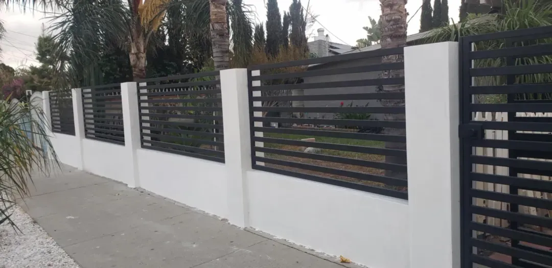 Horizontal slat metal fence on a stucco wall